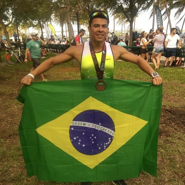 Rômulo com a medalha e a bandeira do Brasil