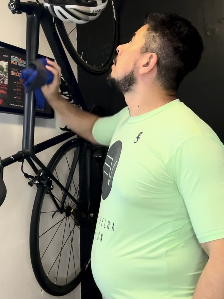 Rômulo hoje, aos 46 anos, ao lado da bike pendurada na parede